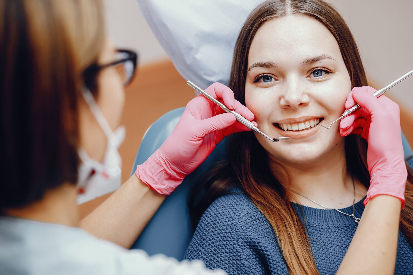 Girl talking to the dendist. Beautiful lady in the dentist's office. Woman in a uniform