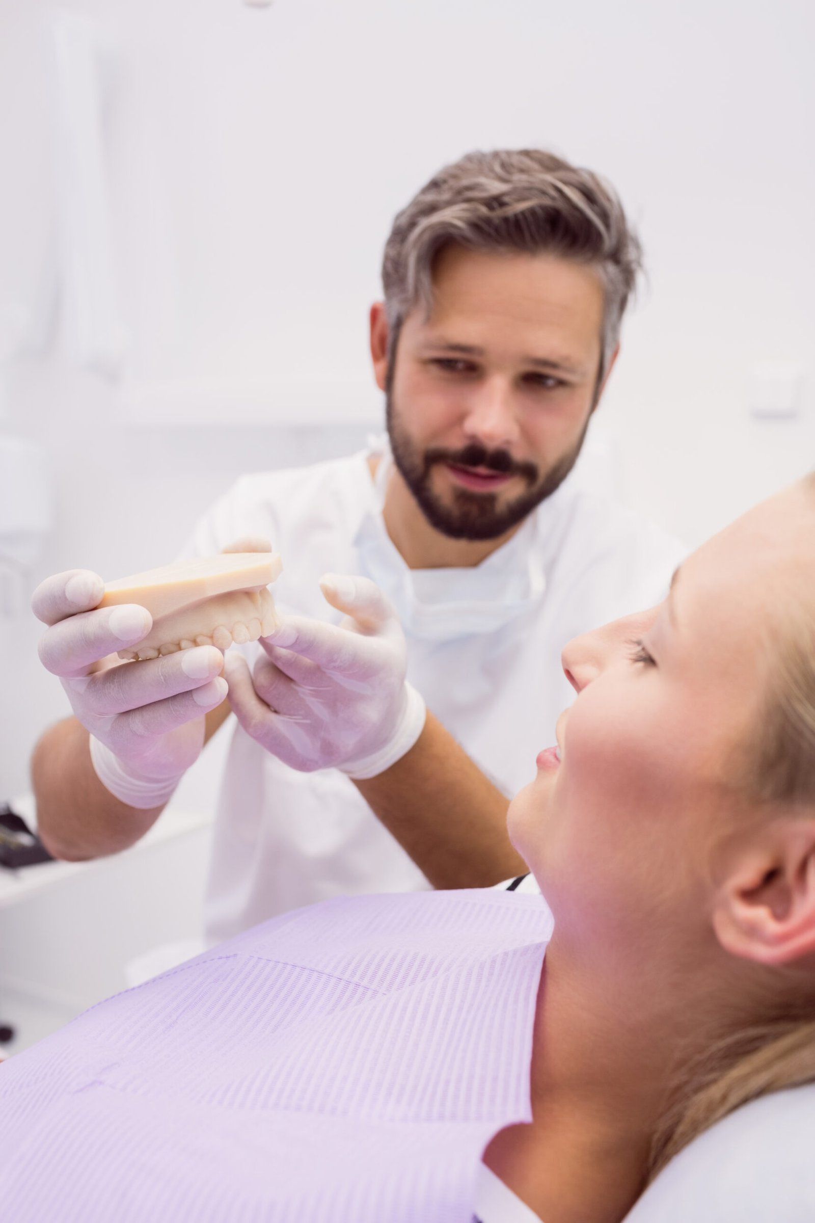 Dentist showing denture model to the patient in clinic